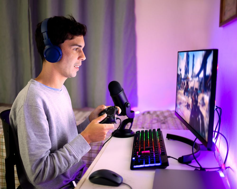 boy playing video games on a computer with a controller